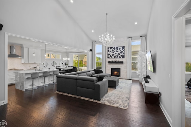 53081 Enclave Cir, Shelby Twp, MI 48315 - living room with a chandelier, high vaulted ceiling, dark wood-style flooring, a fireplace, and recessed lighting
