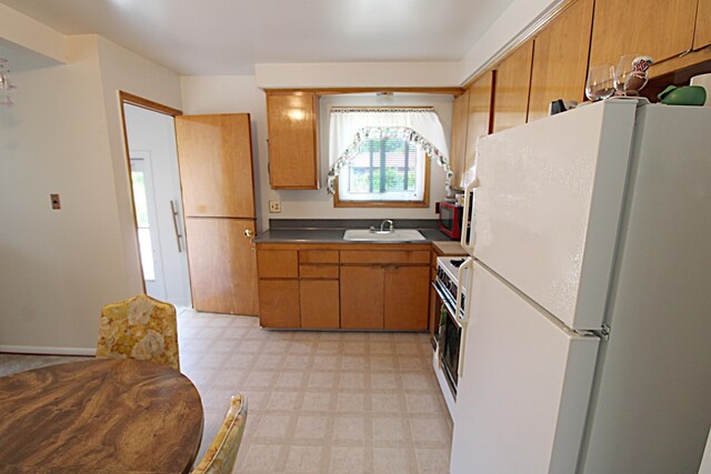 24849 Curie St, Warren, MI 48091 - kitchen with freestanding refrigerator, light floors, and brown cabinets