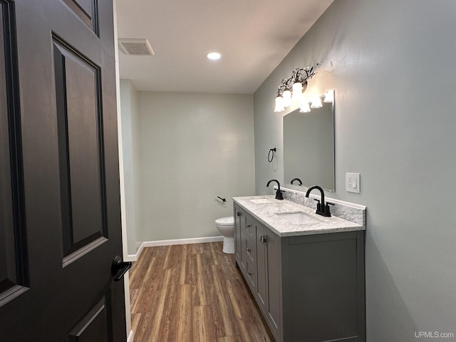 708 Paul Bunyan Ave, Ontonagon, MI 48853 - bathroom featuring double vanity, wood finished floors, and recessed lighting