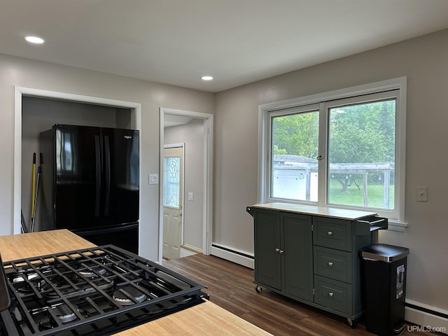 708 Paul Bunyan Ave, Ontonagon, MI 48853 - kitchen with freestanding refrigerator, a baseboard radiator, gas range oven, dark wood-style flooring, and recessed lighting