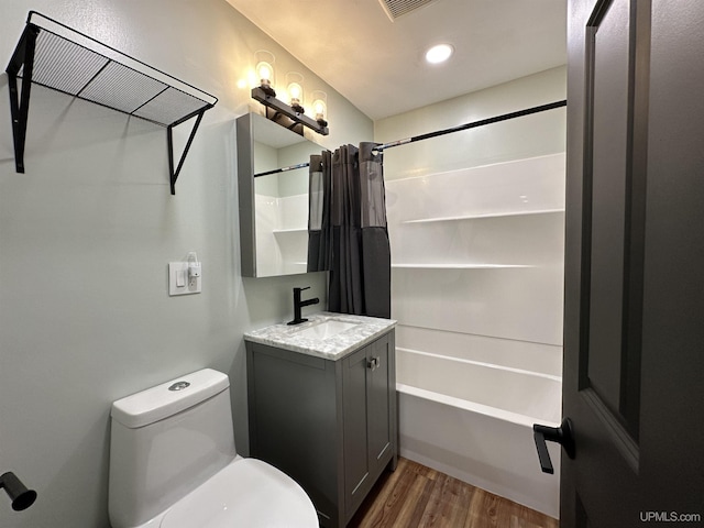 708 Paul Bunyan Ave, Ontonagon, MI 48853 - full bathroom featuring wood finished floors, vanity, shower / bathtub combination with curtain, and recessed lighting