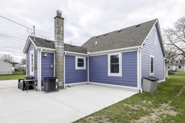 29230 Harding St, Roseville, MI 48066 - rear view of property featuring a patio area, a chimney, a shingled roof, and a lawn