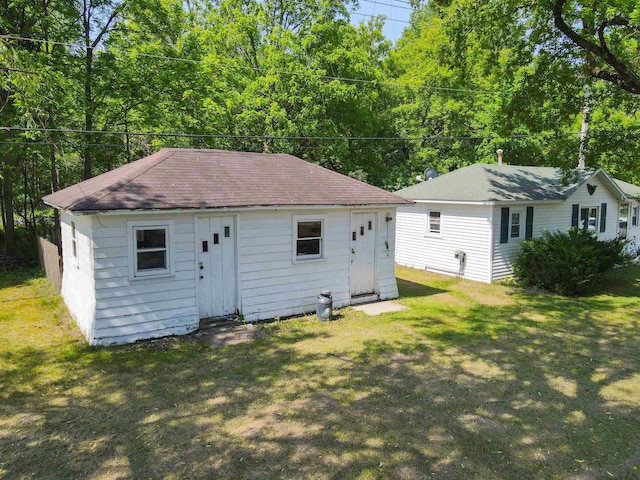 423 W Railway St, Coleman, MI 48618 - back of house with a lawn, roof with shingles, and an outbuilding