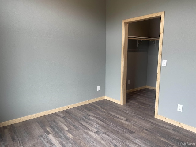 227 W Birch St, Ironwood, MI 49938 - unfurnished bedroom featuring dark wood finished floors, a spacious closet, and a closet