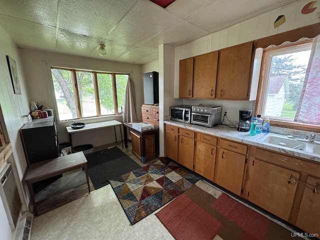301 Kahma Ave, Amasa, MI 49902 - kitchen with light countertops, stainless steel microwave, dark flooring, and brown cabinetry