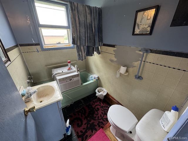 301 Kahma Ave, Amasa, MI 49902 - bathroom featuring tile walls, a tub, vanity, and wainscoting
