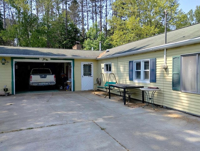 11131 Kaylynn Dr, Lake, MI 48632 - view of side of property with an attached garage, concrete driveway, and a chimney