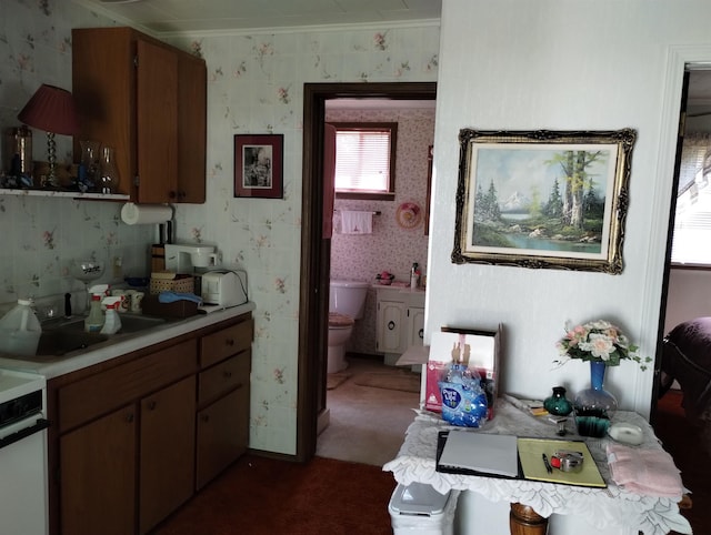 11131 Kaylynn Dr, Lake, MI 48632 - kitchen with light countertops, carpet floors, range, crown molding, and brown cabinetry