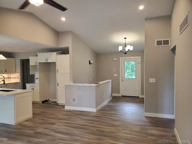 26593 Alray St, Chesterfield, MI 48051 - kitchen with lofted ceiling, dark wood-style floors, white cabinetry, ceiling fan, and a chandelier