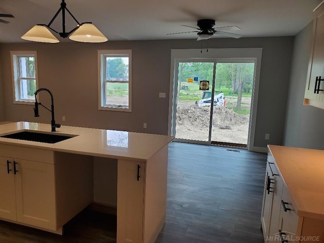 26593 Alray St, Chesterfield, MI 48051 - kitchen featuring ceiling fan, light countertops, white cabinets, dark wood finished floors, and decorative light fixtures