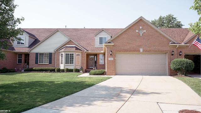 17485 Averhill Blvd, Macomb, MI 48042 - view of front facade featuring brick siding, concrete driveway, a front yard, an attached garage, and a shingled roof