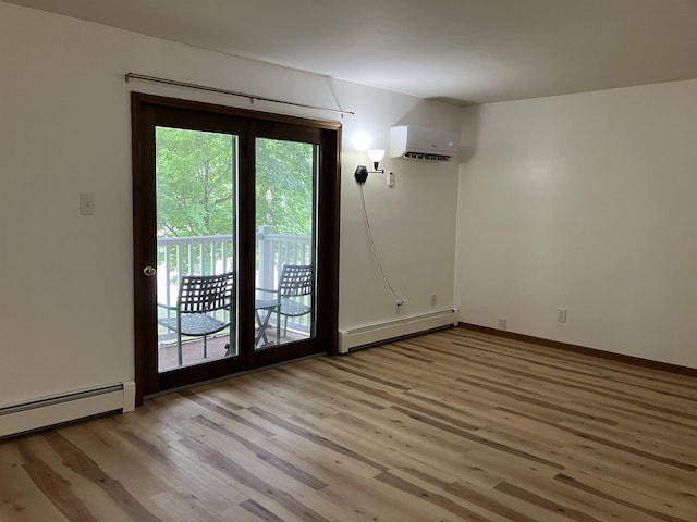 240 N Bowery Ave, Gladwin, MI 48624 - spare room with a baseboard radiator, a wall mounted air conditioner, baseboard heating, and light wood finished floors