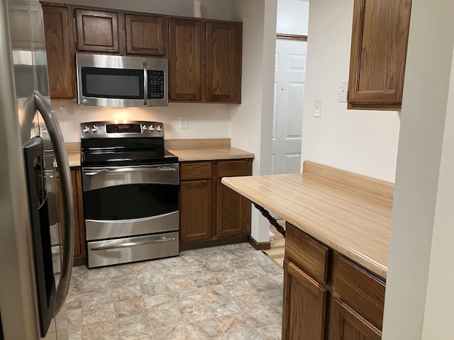 240 N Bowery Ave, Gladwin, MI 48624 - kitchen featuring appliances with stainless steel finishes, light countertops, and stone finish floors