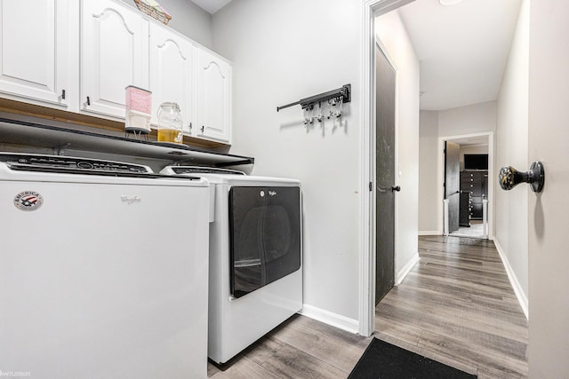 53564 Grace Dr, New Baltimore, MI 48047 - laundry area featuring independent washer and dryer, cabinet space, and light wood-style flooring