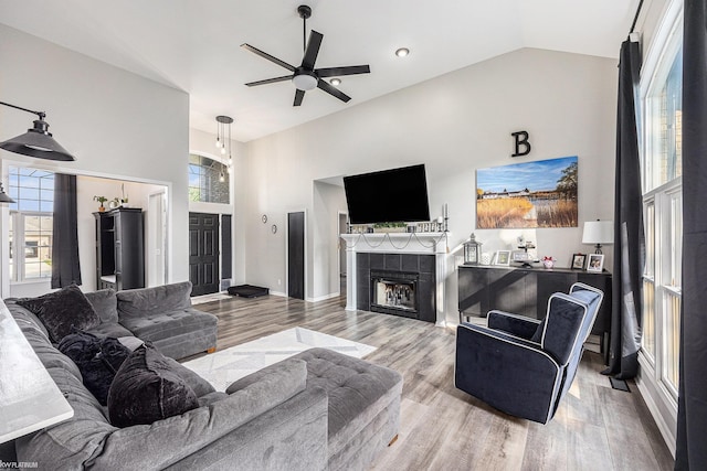 53564 Grace Dr, New Baltimore, MI 48047 - living area featuring ceiling fan, wood finished floors, a tiled fireplace, and high vaulted ceiling