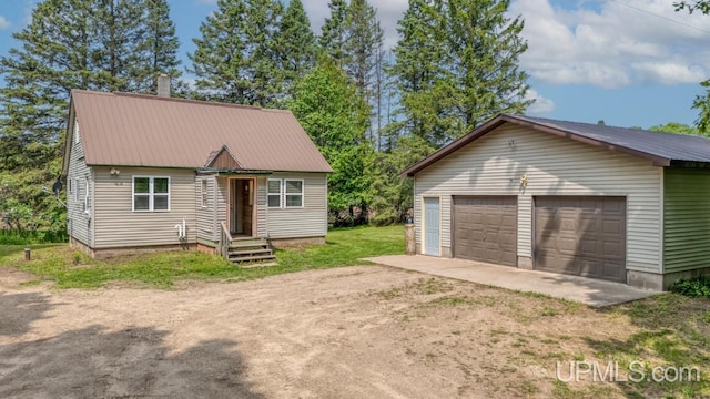 N1953 M67 Hwy, Limestone, MI 49816 - view of front of property featuring a garage, a metal roof, and an outbuilding