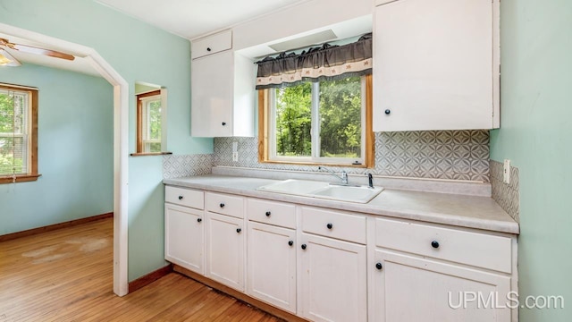 N1953 M67 Hwy, Limestone, MI 49816 - kitchen with white cabinetry, light countertops, light wood finished floors, and decorative backsplash
