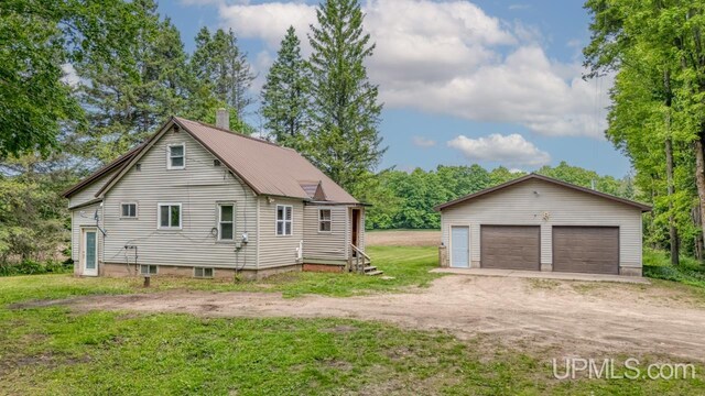 N1953 M67 Hwy, Limestone, MI 49816 - view of home's exterior featuring a detached garage, an outbuilding, a chimney, and a yard