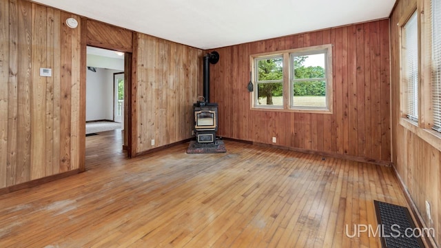 N1953 M67 Hwy, Limestone, MI 49816 - spare room with light wood finished floors, a wood stove, a smoke detector, and wood walls