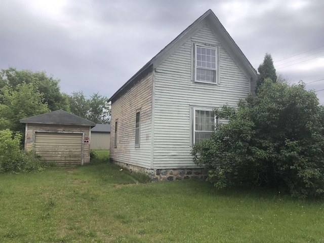 152 N Corning St, Farwell, MI 48622 - view of side of property featuring a detached garage, an outdoor structure, and a yard
