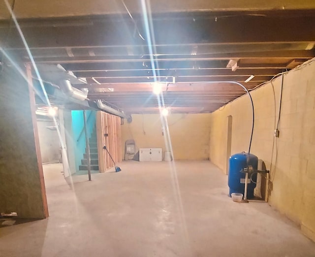 9470 Arbela Rd, Millington, MI 48746 - unfinished basement featuring a water pressure tank and stairs
