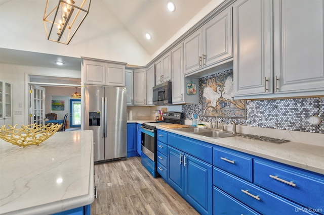15951 Water St, Garden, MI 49835 - kitchen featuring appliances with stainless steel finishes, blue cabinets, decorative backsplash, light wood finished floors, and lofted ceiling