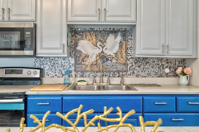 15951 Water St, Garden, MI 49835 - kitchen with appliances with stainless steel finishes, white cabinets, backsplash, light countertops, and blue cabinetry