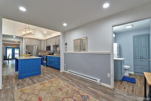 15951 Water St, Garden, MI 49835 - kitchen featuring a baseboard heating unit, stainless steel appliances, wood finished floors, a kitchen island, and light countertops