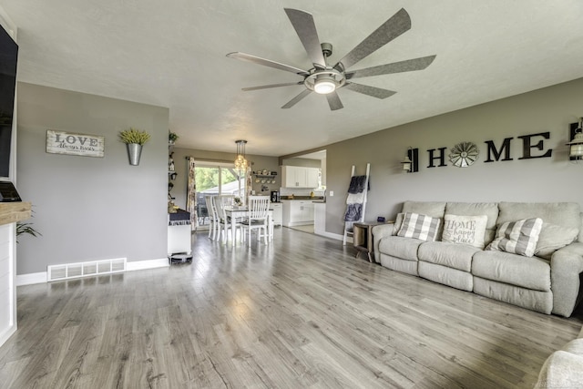 4856 Wagner Rd, Croswell, MI 48422 - living room with a ceiling fan, wood finished floors, and a chandelier