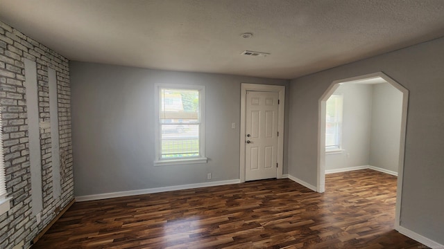 11444 Cadillac St, Warren, MI 48089 - entryway with dark wood finished floors, arched walkways, and a textured ceiling