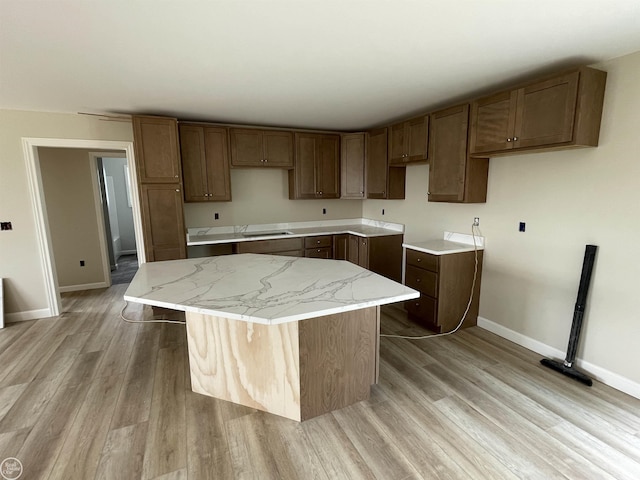 8540 Wildcat Rd, Jeddo, MI 48032 - kitchen with a kitchen island, light wood-style flooring, and light stone countertops
