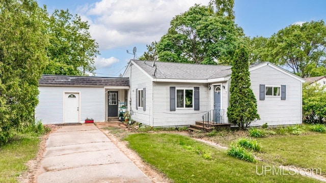 939 N 20th St, Escanaba, MI 49829 - view of front of property with a front yard, roof with shingles, and driveway