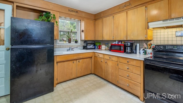 939 N 20th St, Escanaba, MI 49829 - kitchen featuring black appliances, exhaust hood, light countertops, light flooring, and tasteful backsplash