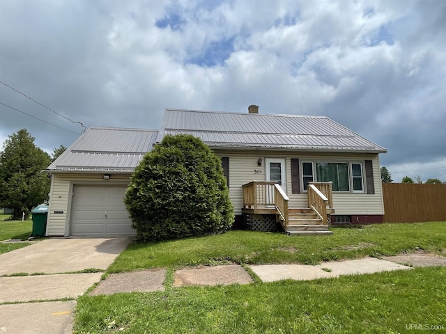 301 N 7th Ave, Hurley, WI 54534 - view of front of home featuring a garage, a chimney, driveway, and a metal roof