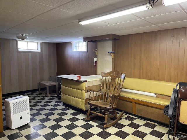301 N 7th Ave, Hurley, WI 54534 - recreation room featuring tile patterned floors, wooden walls, healthy amount of natural light, and a drop ceiling