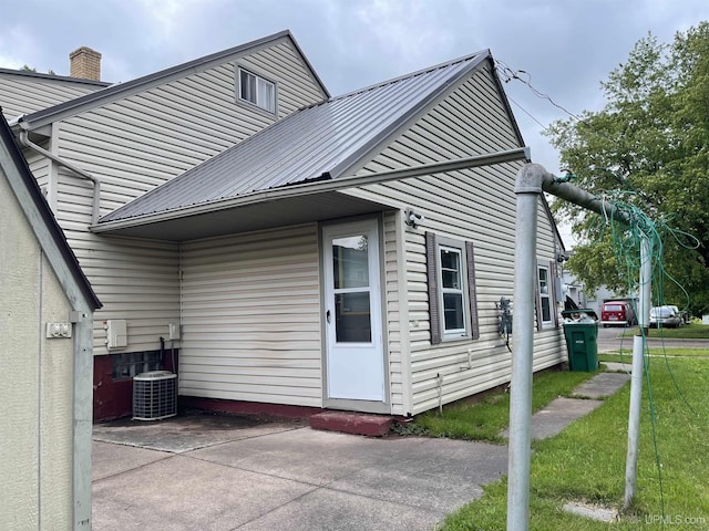 301 N 7th Ave, Hurley, WI 54534 - view of side of home featuring a chimney, a metal roof, and a lawn