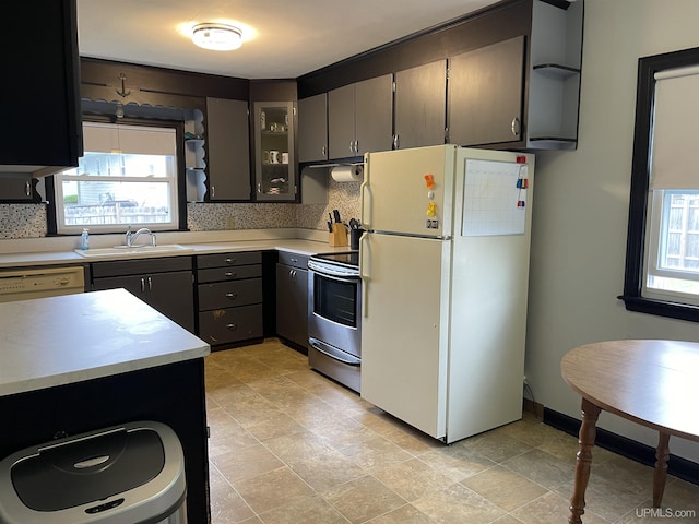 301 N 7th Ave, Hurley, WI 54534 - kitchen featuring white appliances, light countertops, backsplash, glass insert cabinets, and stone finish floors