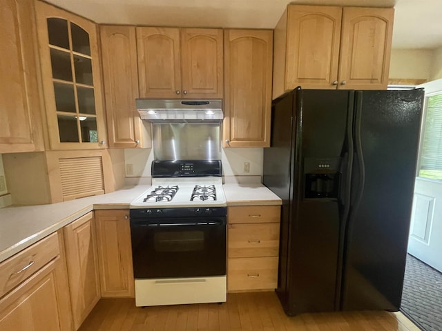 1549 N 7 Mile Rd, Sanford, MI 48657 - kitchen with black refrigerator with ice dispenser, range with gas cooktop, exhaust hood, and light brown cabinetry