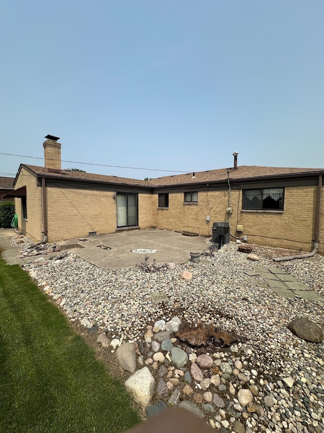 8856 Balboa Ave, Sterling Heights, MI 48313 - rear view of property with brick siding, a chimney, and a patio