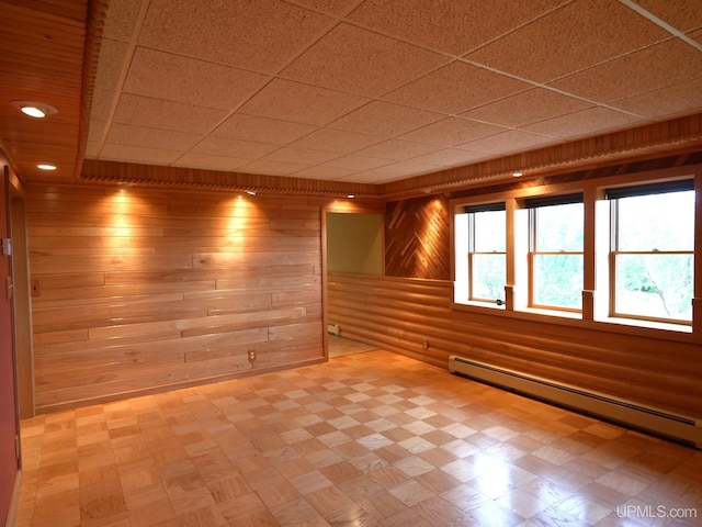 1120 Dextrom Rd, Calumet, MI 49913 - empty room featuring baseboard heating, wood walls, tile patterned floors, and a drop ceiling