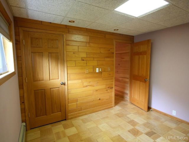 1120 Dextrom Rd, Calumet, MI 49913 - unfurnished bedroom with a baseboard heating unit, wooden walls, and light flooring