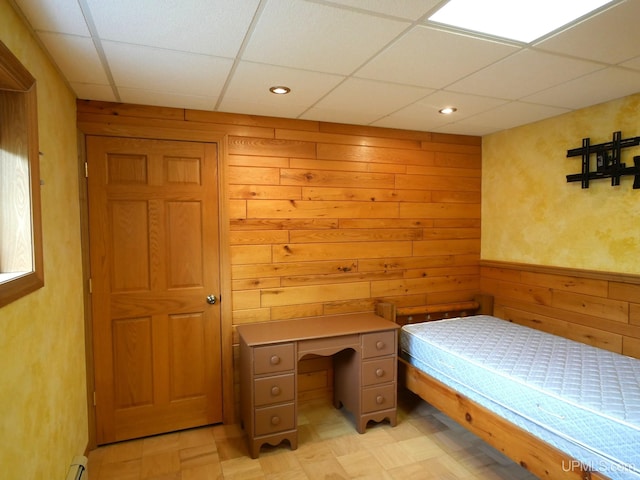 1120 Dextrom Rd, Calumet, MI 49913 - unfurnished bedroom featuring a paneled ceiling, wood walls, and light flooring