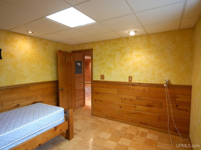1120 Dextrom Rd, Calumet, MI 49913 - bedroom with a paneled ceiling, wainscoting, light floors, and wood walls