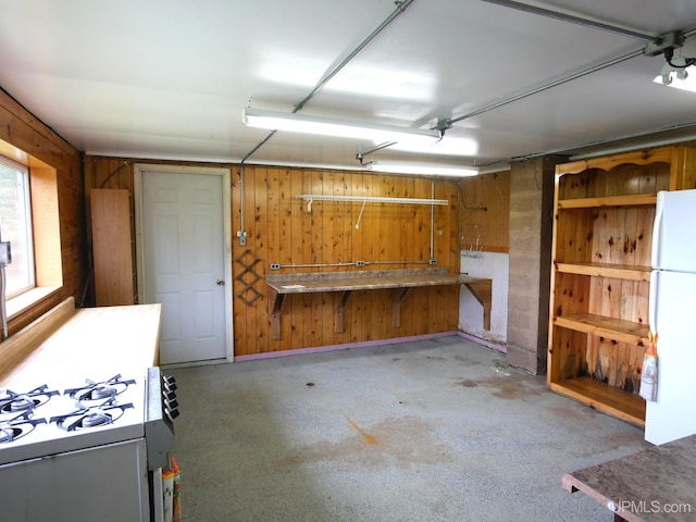 1120 Dextrom Rd, Calumet, MI 49913 - garage featuring freestanding refrigerator, wooden walls, and a workshop area