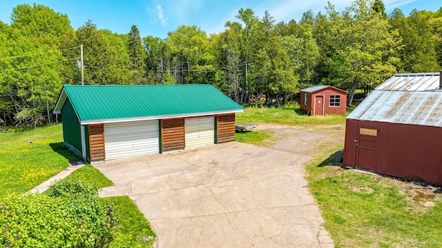 1120 Dextrom Rd, Calumet, MI 49913 - detached garage featuring a storage unit and a view of trees