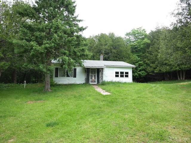 1120 Dextrom Rd, Calumet, MI 49913 - view of front of home with a front lawn, a metal roof, and a chimney