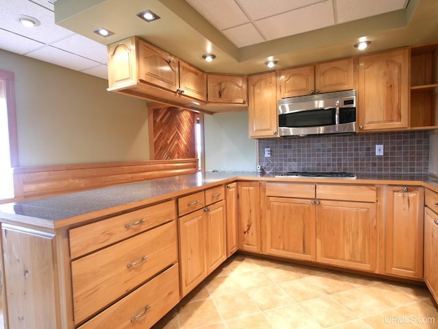 1120 Dextrom Rd, Calumet, MI 49913 - kitchen featuring stainless steel microwave, a paneled ceiling, backsplash, light tile patterned floors, and gas stovetop