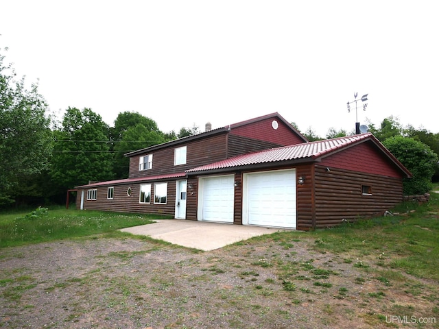 1120 Dextrom Rd, Calumet, MI 49913 - view of front facade featuring an attached garage, log veneer siding, and a metal roof