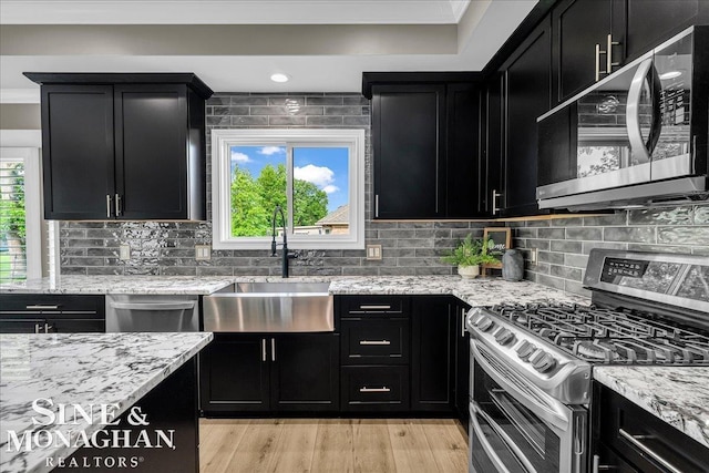 1319 S River Pointe Dr, Saint Clair, MI 48079 - kitchen with appliances with stainless steel finishes, dark cabinetry, light stone counters, crown molding, and recessed lighting