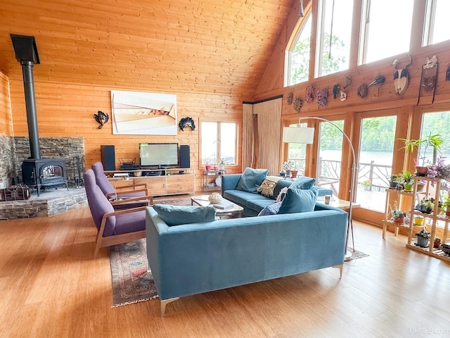 273 N Basin Dr, Negaunee, MI 49866 - living room with high vaulted ceiling, a wood stove, wood finished floors, plenty of natural light, and wood walls